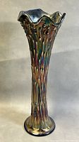 Front angled view of the tall carnivall glass vase showing fluted rim, floral texture and purple amethyst iridescence.
