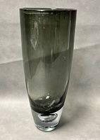 Full view of vase showing tapered cylindrical shape and smoked gray glass with bubble bottom detail.
