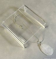Full view of 14-inch sterling silver chain with the translucent stone pendant resting on a clear acrylic stand.
