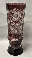 Front view showing purple-to-clear gradient with etched star and floral patterns on the tall crystal vase.