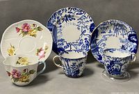 Three pieces including Royal Crown Derby blue and white dessert plate, and two Shelly teacups with matching saucers.