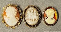 Front view of all three cameos together showing varied sizes and designs