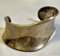 Close-up angle showing the full curved shape and polished reflective surface of the 925 silver cuff bangle bracelet.