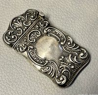 Front view of the antique sterling silver matchstick holder, showing detailed repousse pattern.