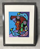Full view of framed Norval Morrisseau print, showcasing the vibrant artwork and gray frame with white mat.