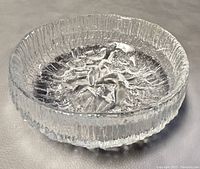 Clear glass bowl with thick footed base, surface textured with vertical ridges and iceberg pattern on base.