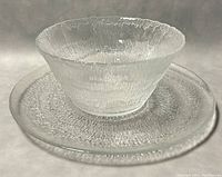 Side view showing the 14-inch round platter with the 9.5 x 4.75-inch bowl placed on top, highlighting the textured linear design.