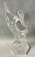 Full side view of vintage clear crystal dancing girl figurine on stepped base.