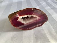Front view of geode showing vivid purple and white crystalline interior with agate bands.