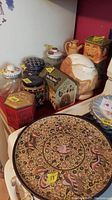Full view of ceramic cat cookie jar, decorative tins, pitcher, jars, and mosaic plate