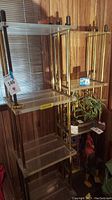 Full view of two lucite and metal framed shelving units showing overall condition, size, and style.