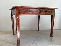 Full front view of oak desk showing top surface, two drawers and legs