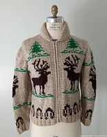 Front view on dress form showing full zip closure, shawl collar and reindeer and pine tree pattern