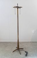 Full view of the Stiffel rocket floor lamp showing brass tone metal construction and tripod base with power cord.