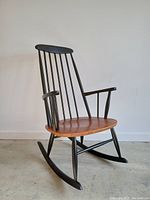 Front three-quarter view showing overall design, teak seat, black-painted beech frame