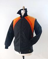 Front view of vintage Ski Doo ski jacket on mannequin showing black base color with yellow, orange, and red color block details on shoulders and chest.