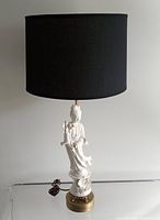 Front view of vintage Blanc de Chine Quan Yin porcelain lamp with black fabric shade