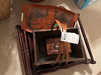 View of stacked wooden trays and carved wooden basket showing the layered and tied arrangement of items.