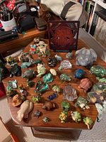 Overall view of the frog figurines collection on wooden table showing various colors and sizes