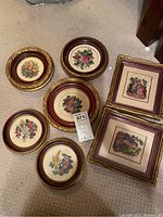 Seven framed petit point needlepoint art pieces, five round floral designs and two rectangular romantic figure scenes.