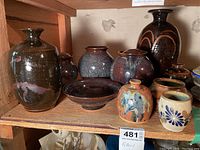 Group shot of multiple pottery pieces on a shelf