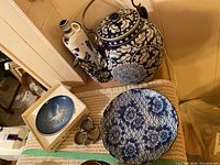 Overview of blue and white pottery collection with jug, teapot, large floral plate, Bing & Grondahl boxed dish, and Wade clover ring dish