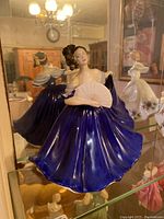 Front and side views of the Royal Doulton Elaine figurine in a blue dress with white fan, showing detailed facial features and flowing dress.