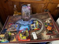 Photo showing all items including Star Wars figures, Knights of the Zodiac figure, frog transformer, and Rubik's Cube on a table.