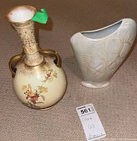 Full view of both vases showing the Doulton Burslem vase with floral and beadwork detail and the pink ceramic vase with floral relief.