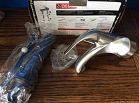 Box showing wear with faucet and mounting hardware wrapped in plastic inside