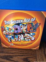 Front cover of boxed set titled The Golden Age of Looney Tunes showing 70 complete uncut cartoons from 1933-1948 with iconic Looney Tunes characters, vibrant colors.