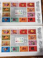 Two full sheets of Hong Kong 1997 Lunar New Year zodiac postage stamps showing all twelve animals in vibrant colors with decorative silver borders.