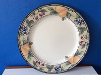 Makasa round ceramic plate with colorful fruit and foliage border on white background