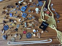 Full assortment of jewelry, cuff links, pins, necklaces including a beaded tassel necklace and faux pearl strand
