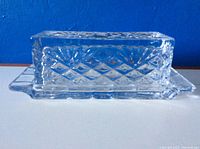 View of the rectangular crystal butter dish showing the diamond cut pattern on the lid and sides with extended wings