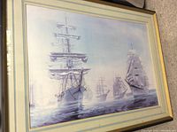 Framed vintage ship artwork showing multiple sailing ships on water with tall sails, signed and dated 1976