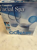 Box front showing Conair Complete Facial Spa with image of the device and steam bowl. Key features noted: automatic shutoff and timer, gentle steam for facial treatments or respiratory therapy.