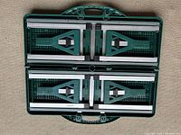 Top view of fold-up picnic table in closed position showing green plastic and metal parts with packing handle.
