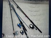 Four fishing rods laid out showing rods and attached reels