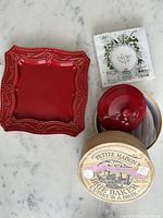 Top view of all items showing heart design plate, brie baker with box, small red ceramic dish, and napkins