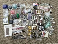 Overview photo of the entire lot showing arranged beads, wires, chains, and findings on a carpeted surface