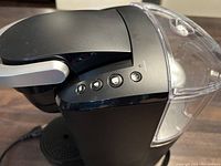 Close-up side-top view of Keurig coffee maker showing control buttons and water reservoir.