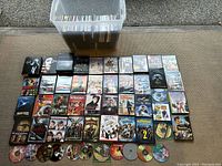 Wide shot of DVDs spread on carpet next to plastic storage bin