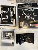 Open box showing stack of fitness guidebooks and DVD cases.