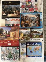 Photo showing all eight puzzles including Great Wall of China, London cityscape, San Francisco cable car, dress shop, seaside scenes, winter holiday scene, and world map puzzles.