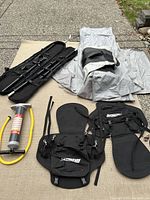 Overview of deflated boat hull, two seat modules, oar case and hand pump laid out