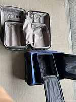 Green hard cover suitcase open showing light beige interior with compartments and mesh zipper pocket.