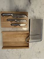 Knives in wooden box and metal slicer placed side by side on countertop