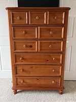 Front view of tall six drawer wooden dresser showing drawer arrangement and finish.