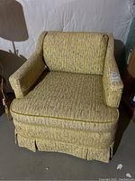 Front view of vintage yellow upholstered side arm chair showing textured fabric and cushioned seat.